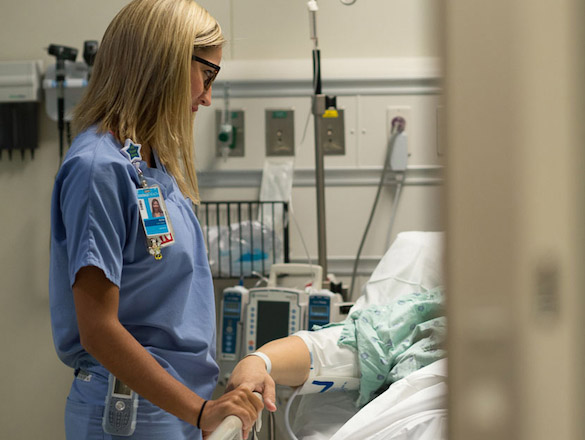 Female nurse standing at patient's bedside