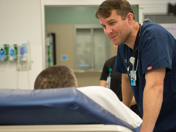 Male provider talking to a patient in a bed