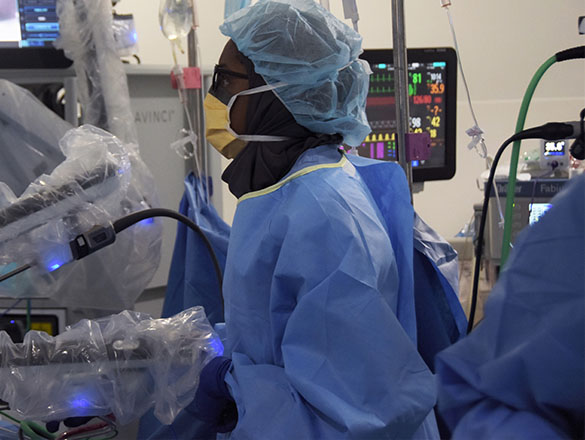 Physician in OR using robotics equipment