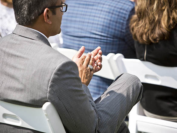 Man sitting down at event and clapping