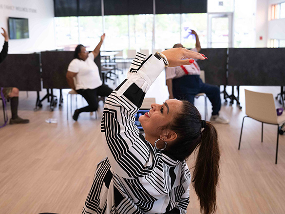 Woman leading an exercise class with participants in the background