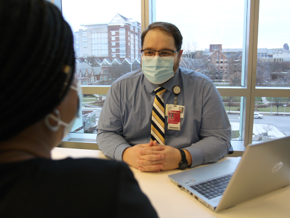 Provider sitting behind a desk talking to a research participant