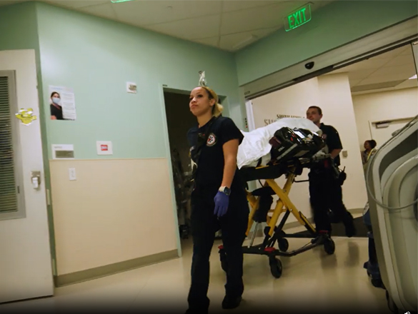A trauma team wheels a patient through the halls of the hospital